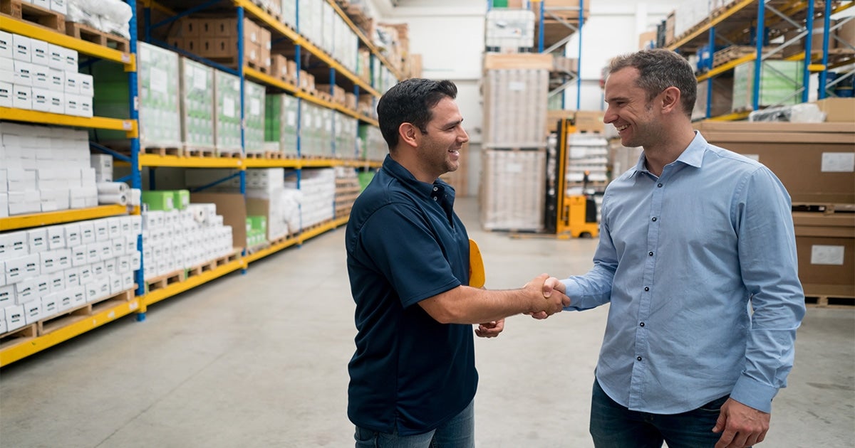 Supply Chain Professionals Shaking Hands in Warehouse